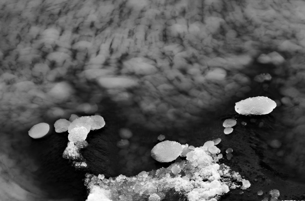 Lumparn, Lumparland, The Åland Islands. Black and white image of pieces of sea ice moving in the water. 