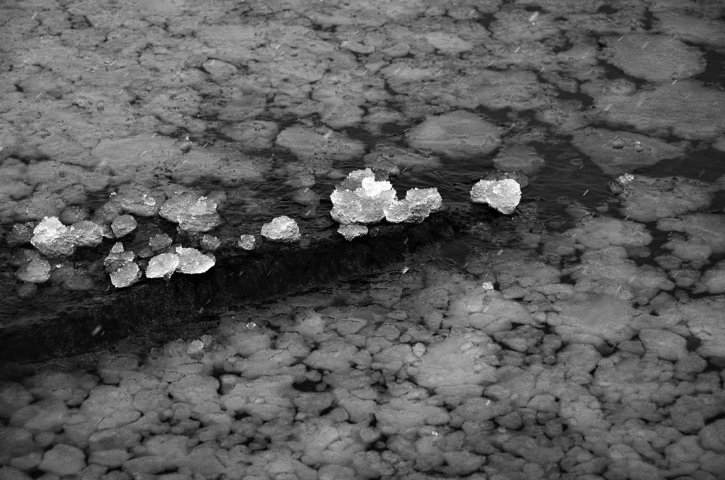 Lumparn, Lumparland, The Åland Islands. Black and white image of pieces of sea ice lying on a small cliff. 