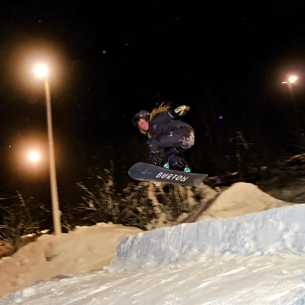 Malva Lomner gör en grab med snowboard i hoppet på Germundö Alpin, Åland.