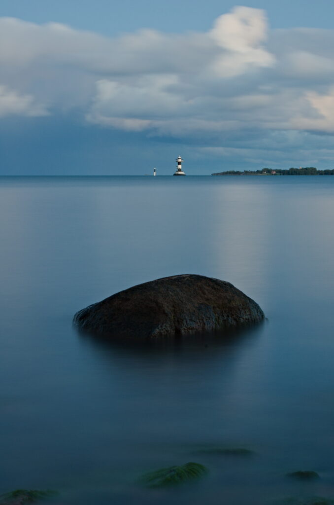 A stone and the lighthous at Ledfjärden from Herröskatan nature reserve, The Åland Islands.