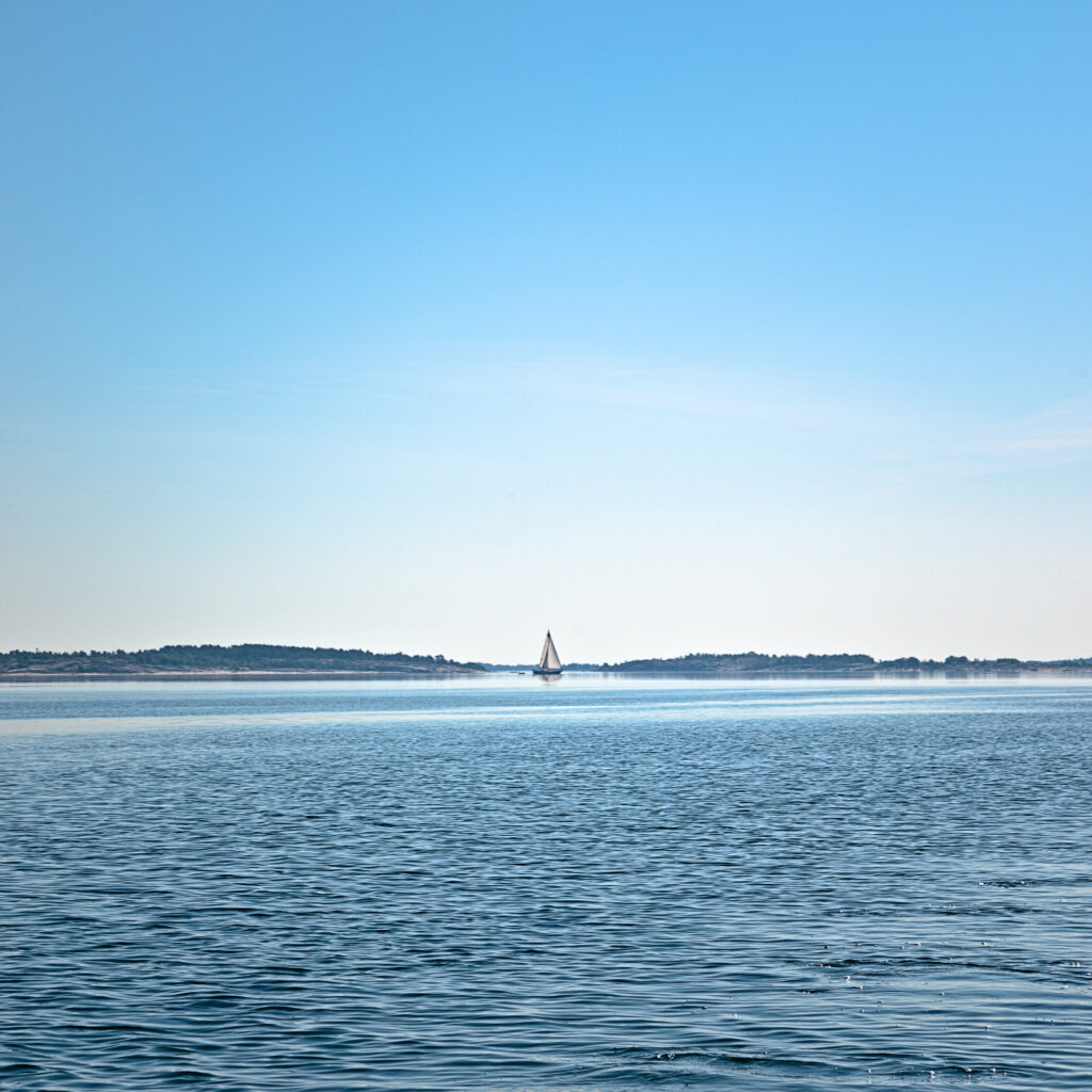 Segelbåt passerar utanför Asterholma en högsommardag 2022.